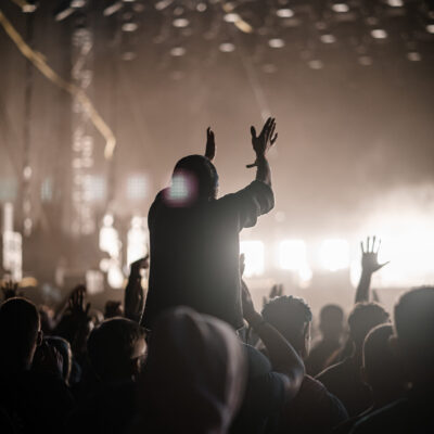 A vertical shot of a group of people who enjoy a rock concert